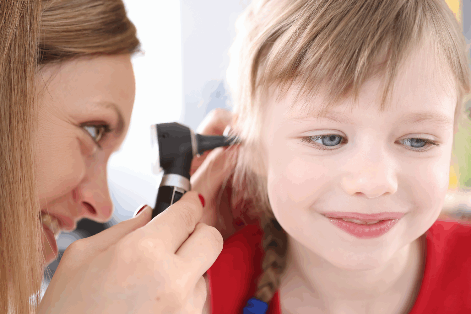 Audiologist looking at ear Audiologist looking at ear
