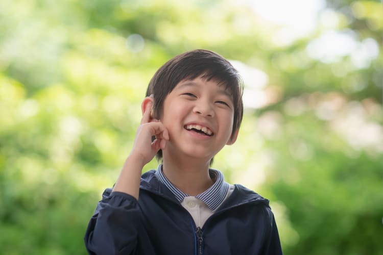 shutterstock_1998573731 Close-up of young boy being fitted with a hearing aid (ANURAK PONGPATIMET/Shutterstock.com)