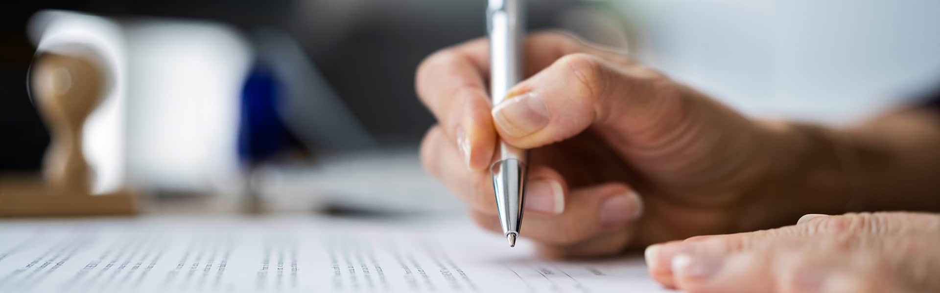 A hand signing papers / shutterstock.com