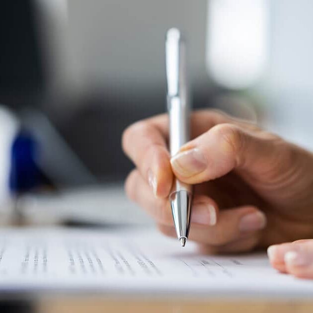 A hand signing papers / shutterstock.com