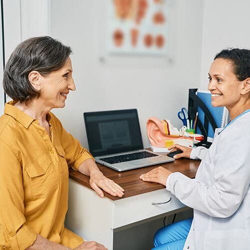 Consultation,With,Experienced,Female,Audiologist,To,Mature,Woman,Patient,At Consultation with experienced female audiologist to mature woman patient at medical clinic. Treatment of hearing loss in senior people